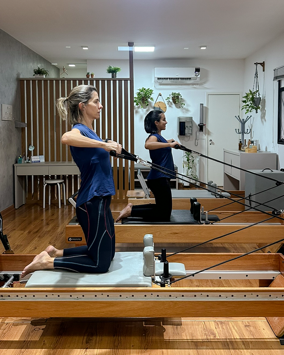 Duas mulheres praticando pilates no studio corpo pilates.